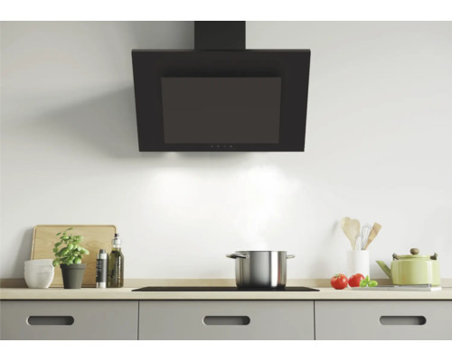 Scène de cuisine avec hotte aspirante, plaque de cuisson et ustensiles de cuisine sur un plan de travail.