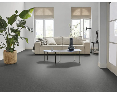 Heller Wohnraum mit grauer Bodenfläche, Sofa und Zimmerpflanze