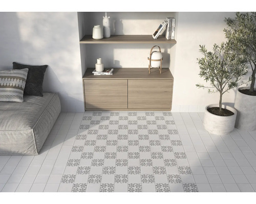 Badezimmer mit Couch, Holzkommode, Regalen und Bodenfliesen mit Muster