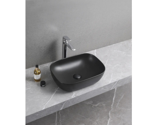 Schwarzes Aufsatzwaschbecken mit Armatur auf Marmorplatte