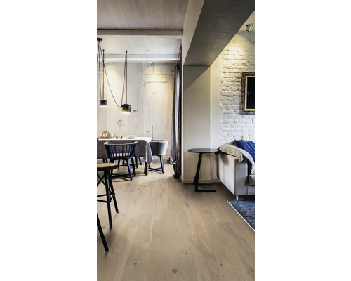 Salon lumineux avec parquet, table à manger et canapé