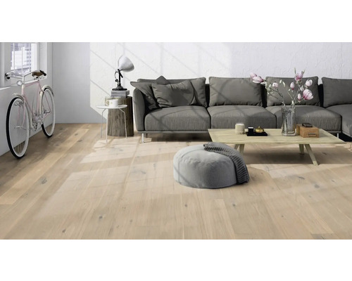 Espace de vie lumineux avec plancher en bois, canapé et vélo