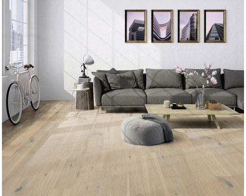 Séjour lumineux avec parquet, canapé, table et vélo.