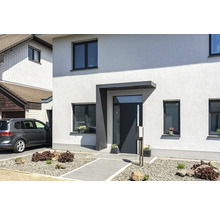 Modernes Einfamilienhaus mit Eingangsbereich, Fenstern und gepflastertem Gartenweg