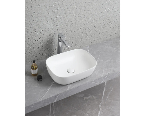 Aufsatzwaschbecken aus Keramik auf einer Ablage mit Armatur