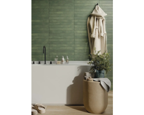 Badezimmer mit grünen Fliesen, Badewanne und Bademantel
