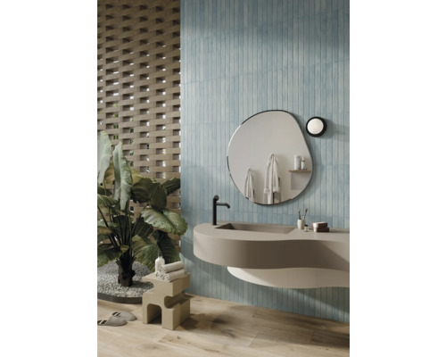 Badezimmer mit Waschbecken, Spiegel und blauen Wandfliesen