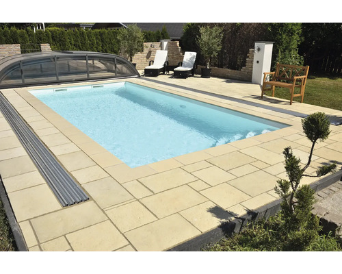 Schwimmbad mit Abdeckung, umgeben von Steinterrasse und Gartenmöbeln