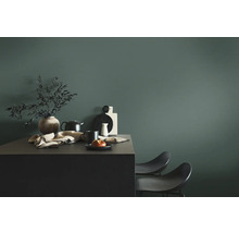 Nature morte avec vase, vaisselle et chaises devant un mur coloré