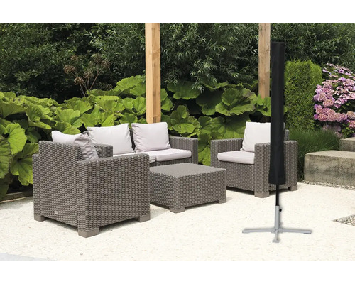 Scène de jardin avec coin salon en rotin gris et housse de protection noire pour parasol