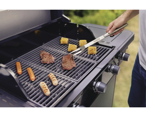 Grillszene mit Steaks, Würstchen und Maiskolben auf einem Grillrost