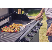 Gemüse wird auf einem Gasgrill mit Grillwender zubereitet.