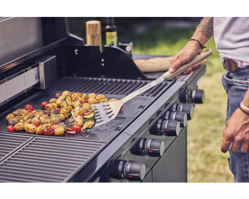 Gemüse wird auf einem Gasgrill mit Grillwender zubereitet.