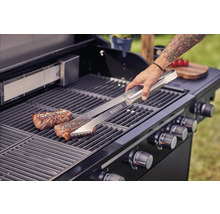 Scène de barbecue avec pince, steak et gril à gaz