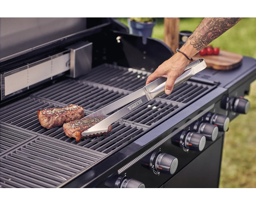 Scène de barbecue avec pince, steak et gril à gaz