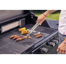 Une personne grille des saucisses, du lard et des épis de maïs sur un barbecue.
