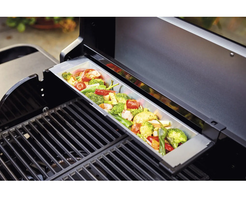 Légumes dans une barquette pour barbecue sur une grille de barbecue