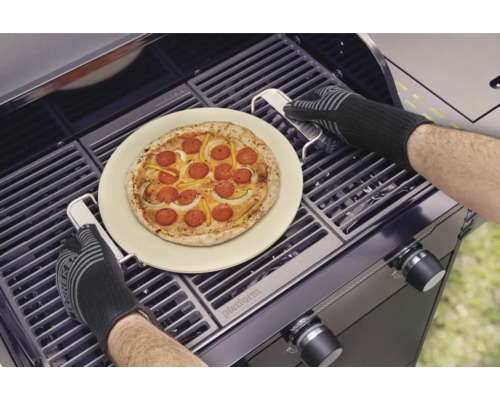 Pizza sur pierre à pizza en préparation sur un barbecue avec des gants de barbecue.