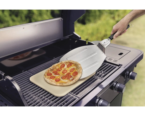Pizza auf einem Pizzastein auf einem Grill mit Pizzaschieber