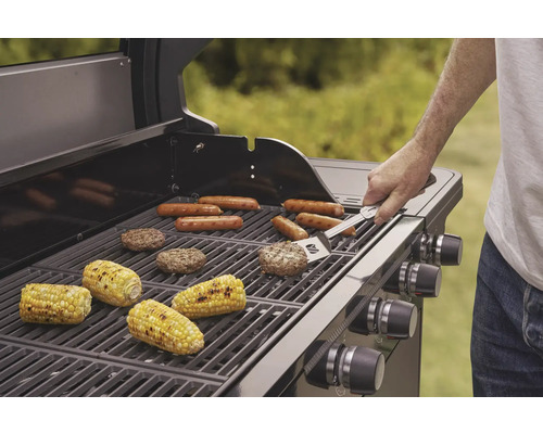 Gril à gaz avec saucisses, épis de maïs et galettes de hamburger sur la grille