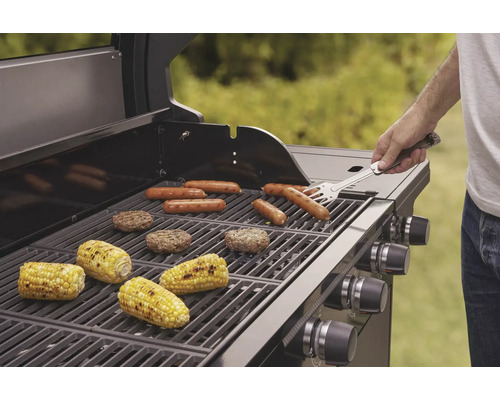 Barbecue avec saucisses, hamburgers et épis de maïs sur la grille