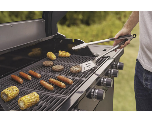 Grill mit Maiskolben, Bratwürsten und Burgerpatties im Freien