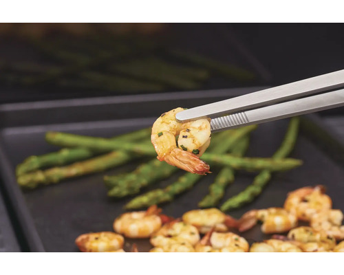 Gegrillte Crevetten mit Spargel, serviert mit Grillzange.