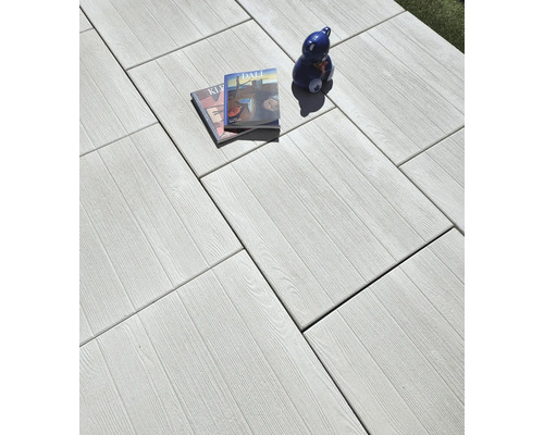 Dalles de terrasse claires avec structure en bois, magazines et décoration