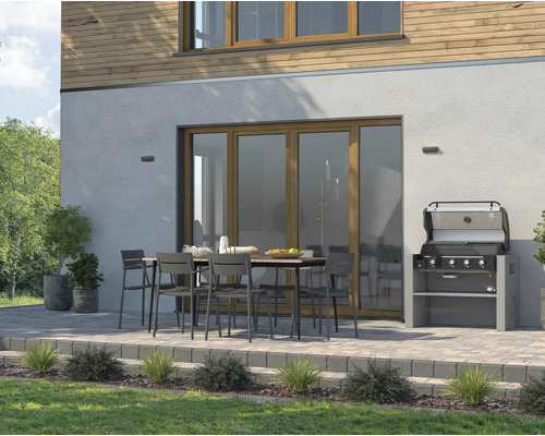 Aussenbereich mit Gartengrill, Esstisch und Stühlen vor einem Haus