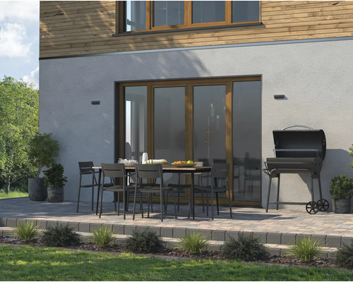 Aussenbereich mit Gartentisch, Stühlen und Grill auf einer gepflasterten Terrasse