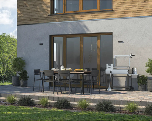 Aussenbereich mit Esstisch, Stühlen und Grill vor einem Haus