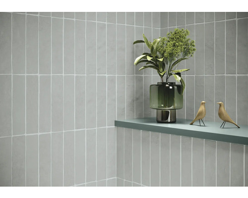 Wandgestaltung mit hellen, länglichen Fliesen, Ablage mit Dekoration