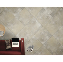 Carreaux de sol clairs dans un salon avec canapé, table et ordinateur portable.