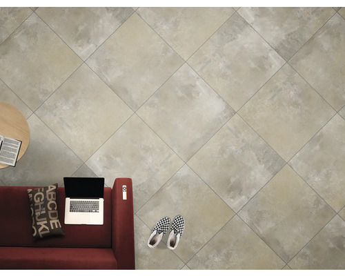 Carreaux de sol clairs dans un salon avec canapé, table et ordinateur portable.