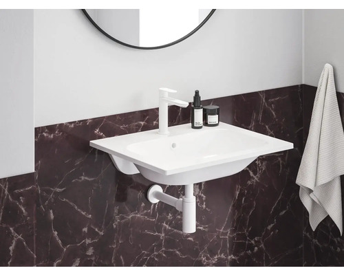 Lavabo avec robinet, siphon et serviette dans la salle de bain