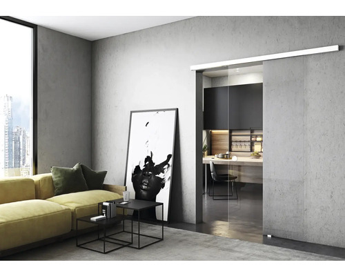 Salon avec canapé jaune, tables basses et porte coulissante en verre donnant sur la cuisine