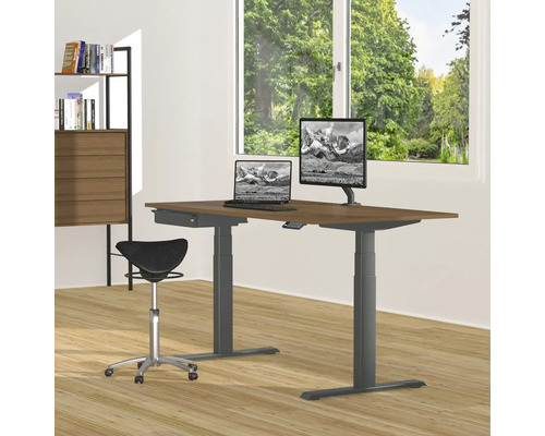 Bureau réglable en hauteur avec ordinateur portable, écran et chaise de bureau dans une pièce lumineuse.