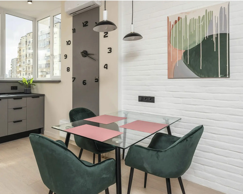 Esszimmer mit Glastisch, grünen Stühlen und Wandkunst