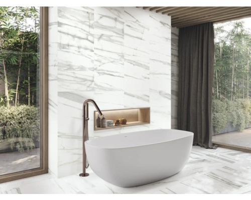 Salle de bains moderne avec baignoire îlot, robinetterie et carrelage en marbre.