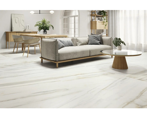 Salon lumineux avec carrelage imitation marbre, canapé, table et chaises.