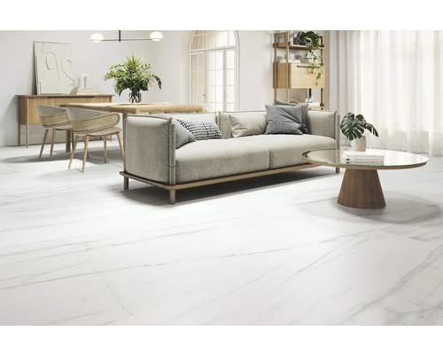 Salon avec canapé, table et carrelage au sol imitation marbre.