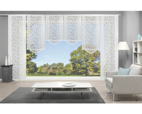 Salon avec rideaux coulissants à motifs de feuilles devant une fenêtre