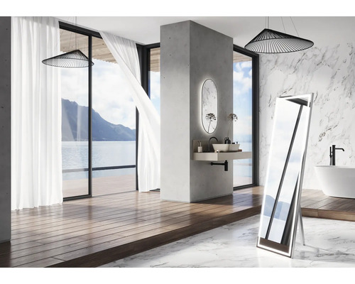 Salle de bain avec miroir autoportant, lavabo, baignoire et vue sur la mer