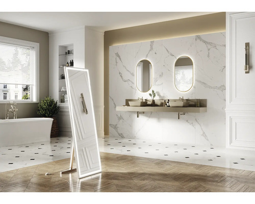 Salle de bains lumineuse avec baignoire, meuble-lavabo avec deux lavabos, deux miroirs éclairés et un miroir sur pied éclairé