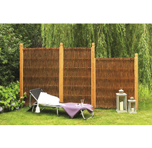 Scène de jardin avec brise-vue en osier et poteaux en bois, chaise longue et lanternes