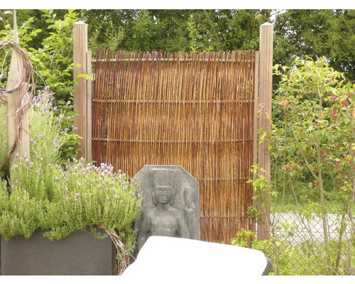 Clôture de protection visuelle en osier avec poteaux en bois dans le jardin