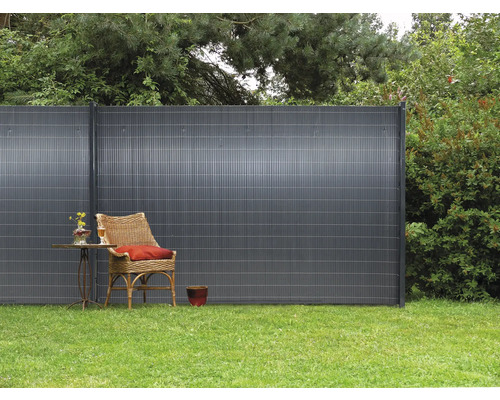 Scène de jardin avec clôture d''intimité, fauteuil et table sur gazon