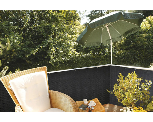 Tapis de protection visuelle sur un balcon avec parasol, fauteuil et plantes