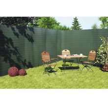 Scène de jardin avec écran de confidentialité, table de jardin et chaises sur la pelouse