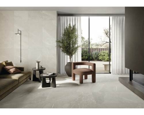 Salon lumineux avec carrelage, canapé, fauteuil, plante d''intérieur et lumière du jour.